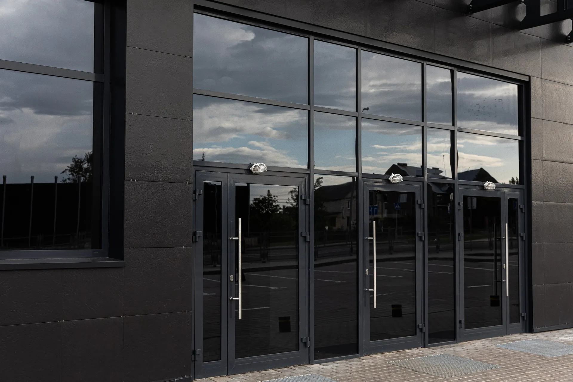 Modern commercial building with dark architectural glass windows and glass entry doors